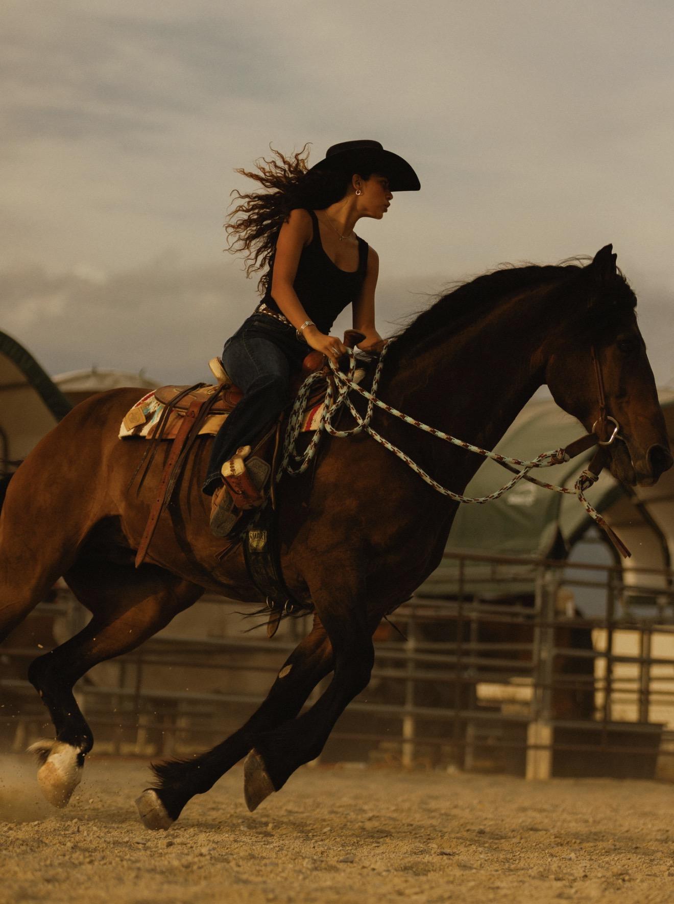 Kiya riding her horse at full gallop in the arena